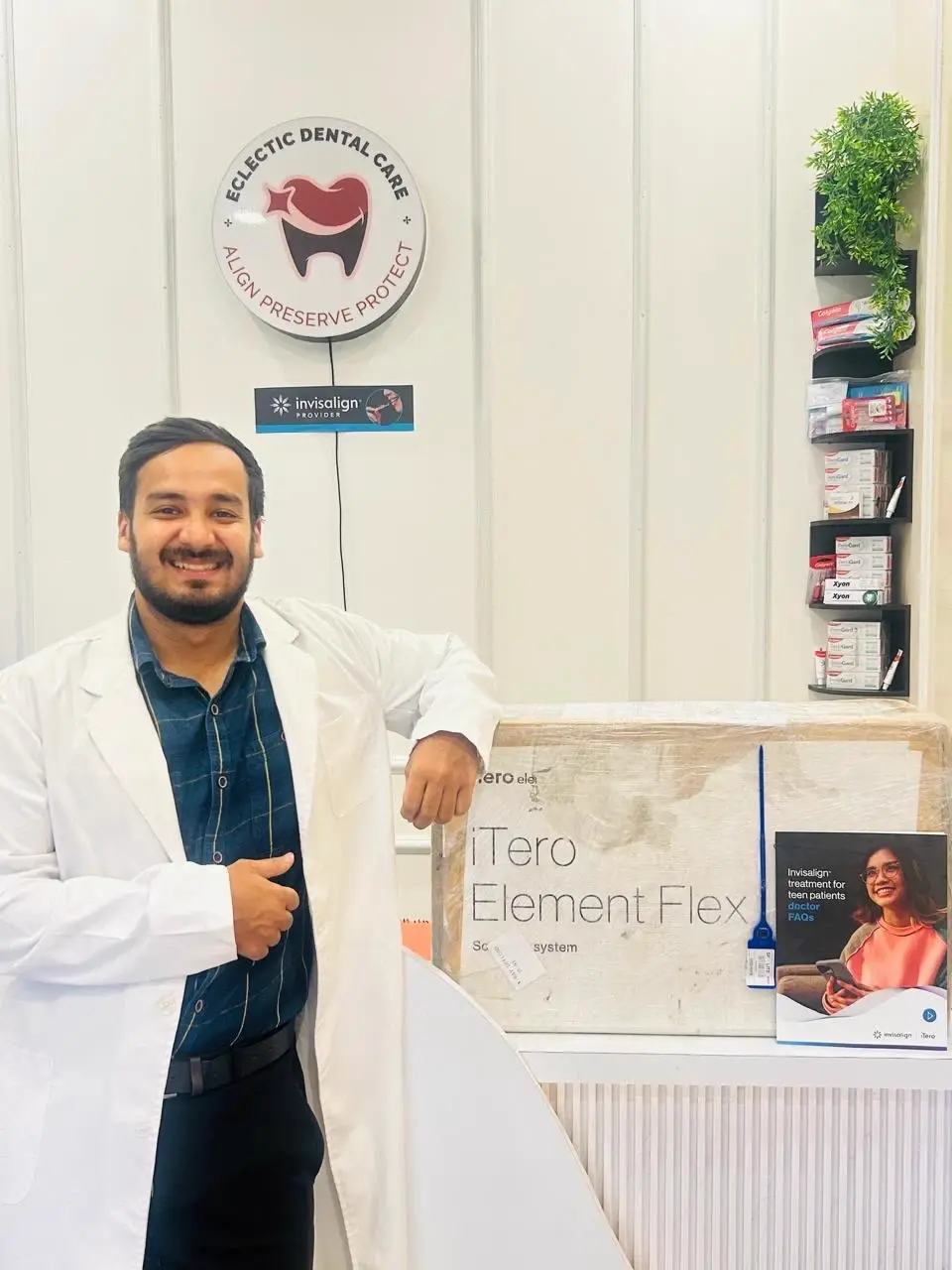 Dr. Umang Malviya beside the Invisalign Provider signage and iTero Element scanner