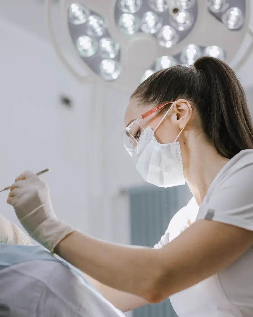 A dentist examining a patient's teeth before fitting a crown