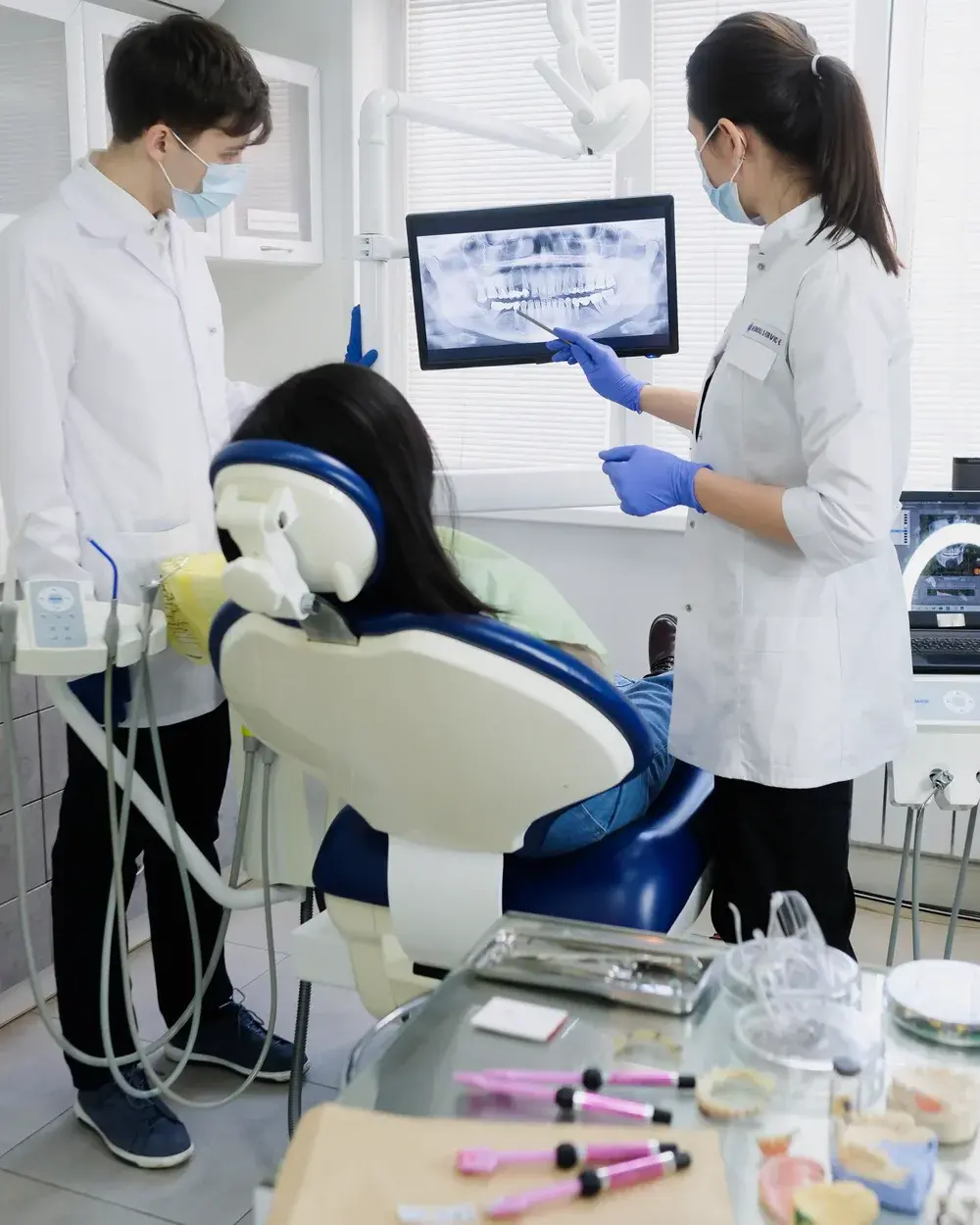 Two dentists reviewing a dental X-ray to plan root canal treatment