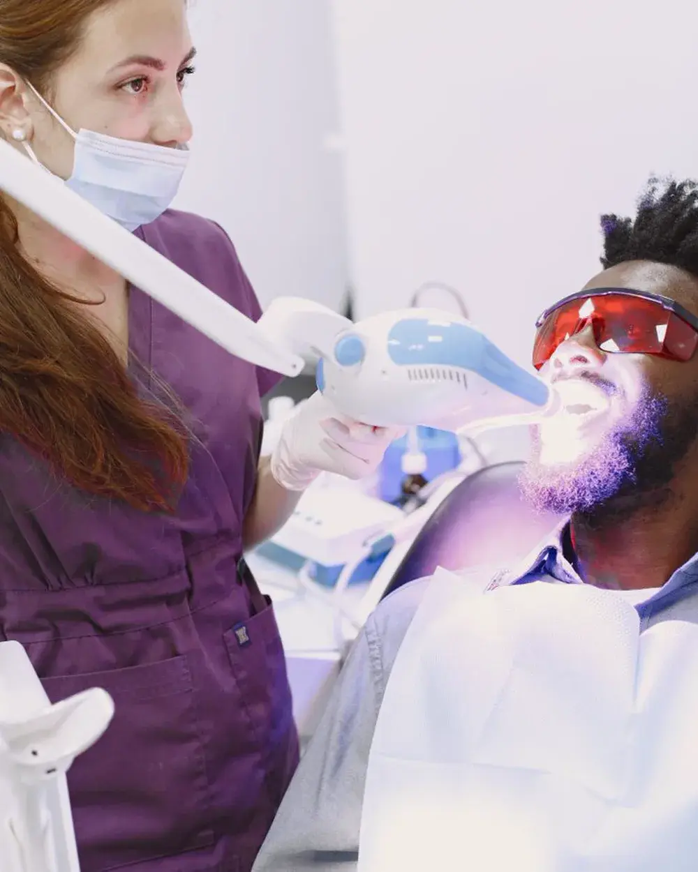 A professional teeth whitening treatment being carried out in a dental chair